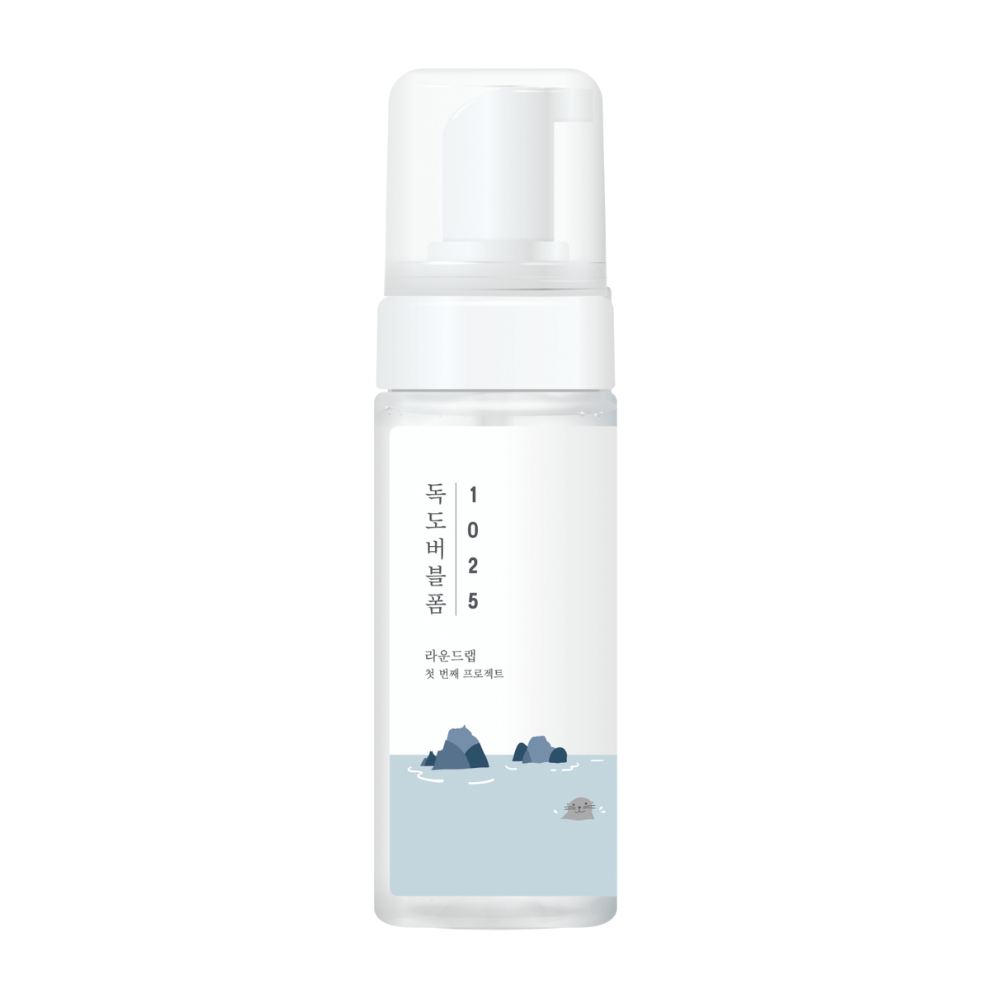 1025 Dokdo Bubble Foam" is a facial cleansing product from ROUND LAB, packaged in a white pump bottle with a simple and clean design, adorned with text and minimalist illustrations of seascapes. 