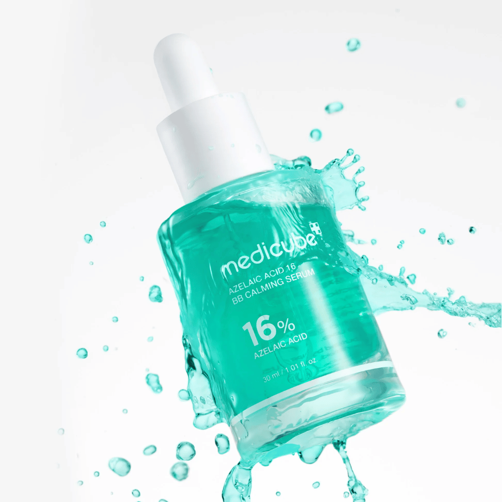 Dynamic product image of Medicube Azelaic Acid 16 BB Calming Serum surrounded by water splashes that emphasize a fresh, light, and hydrating feel.