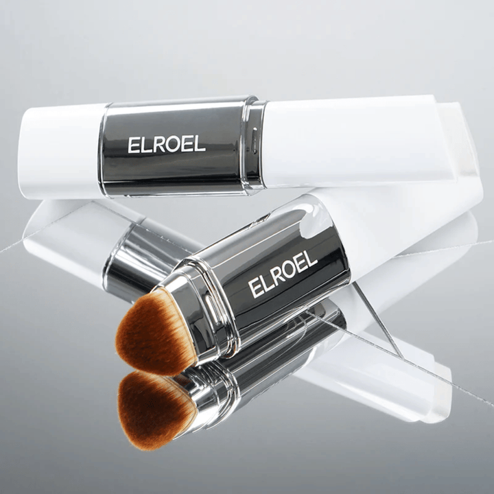 ELROEL Blanc Cover Cream Stick with an integrated brush placed on a mirror surface to show soft bristles and even application.