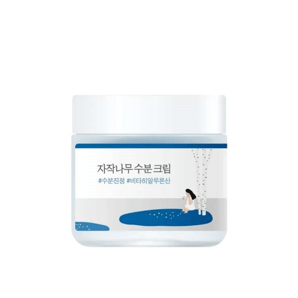 Round Lab Birch Juice Moisturizing Cream in a transparent jar with a white lid and blue label with an illustration of birch and girl, isolated against a white background.
