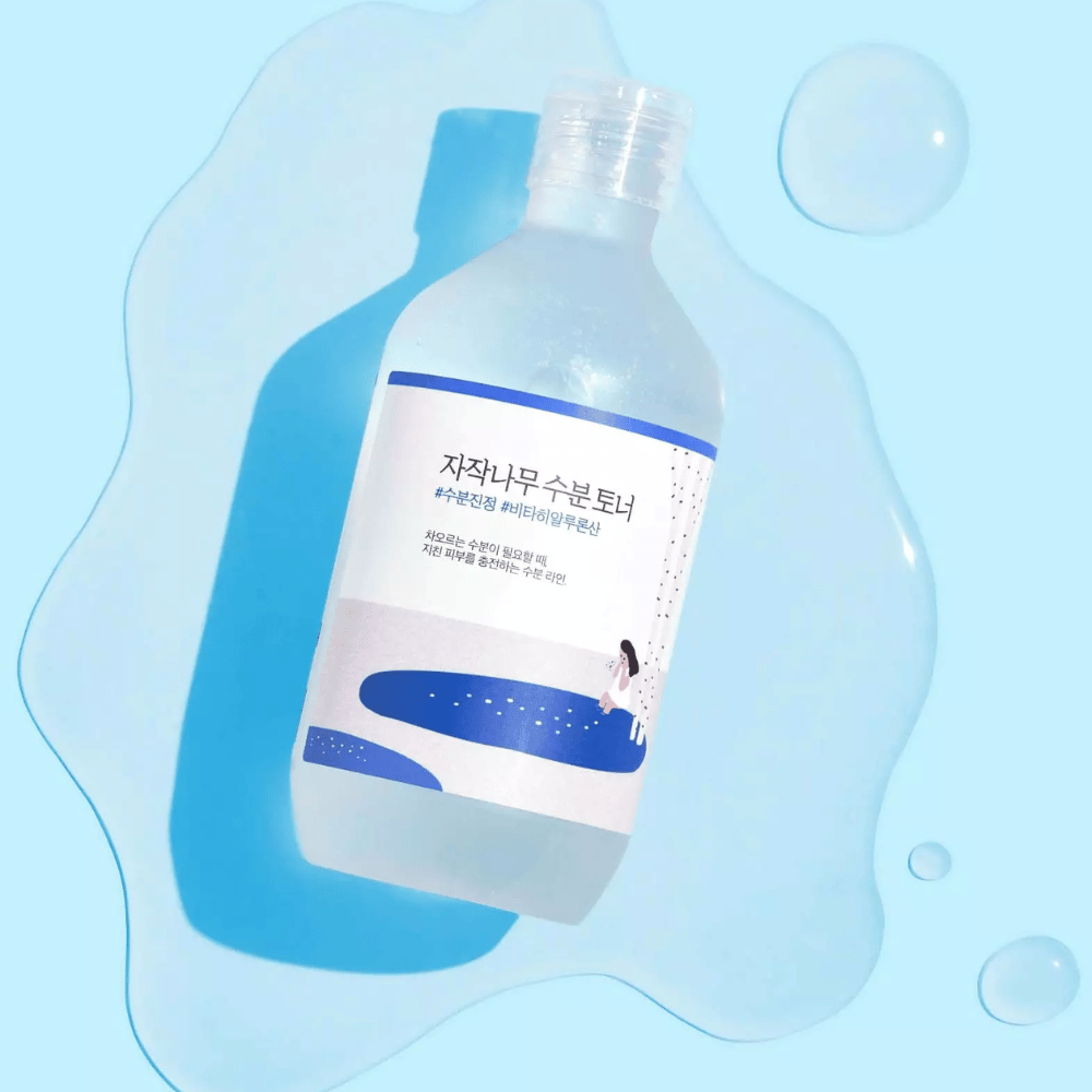 The bottle is lying tilted in a water-like liquid with droplets around it on a blue background