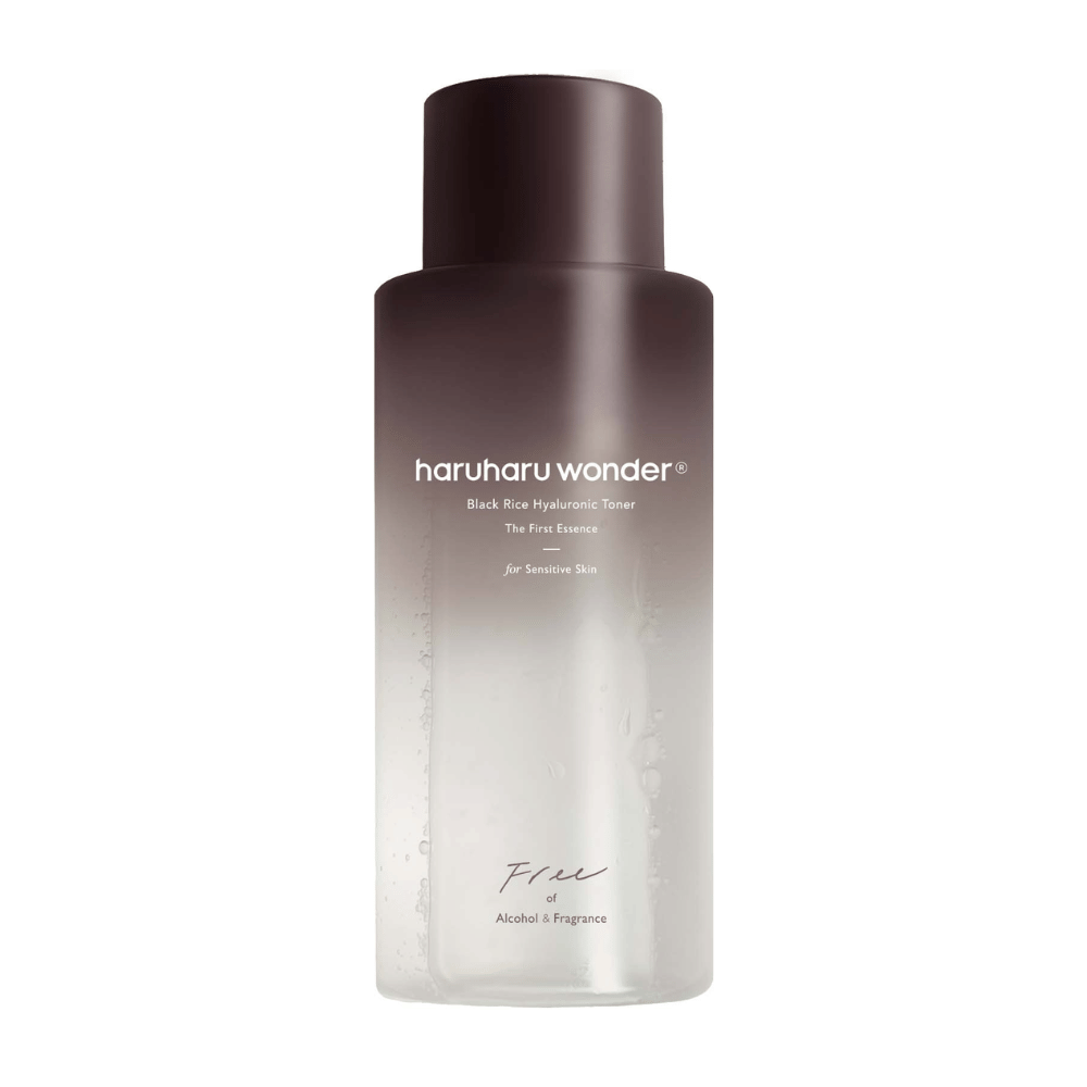 A bottle of haruharu wonder Black Rice Hyaluronic Toner The First Essence, with a dark brown to transparent gradient and the text "Free of Alcohol & Fragrance", on a white background.