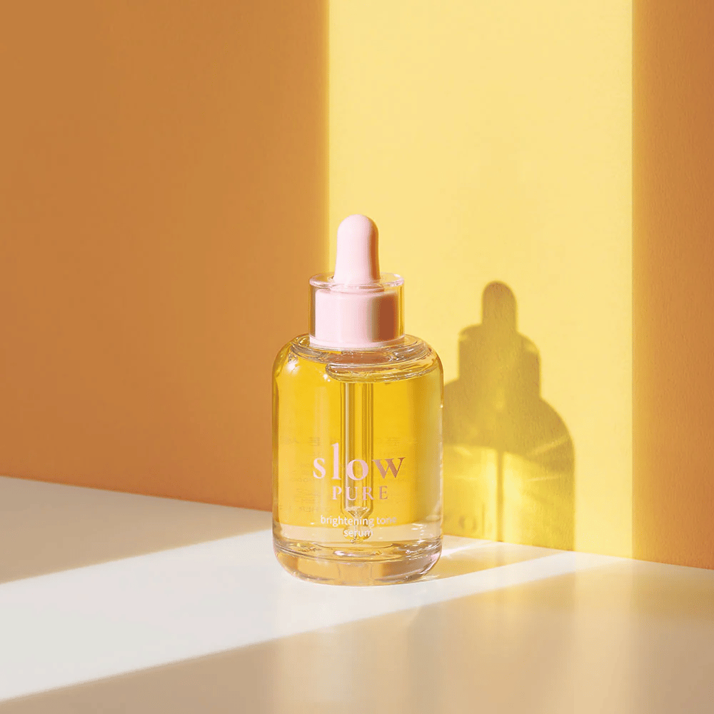 Slow Pure Brightening Tone Serum in sunny yellow light, symbolizes radiance and energy for the skin.