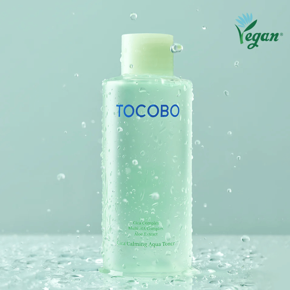 Product image of TOCOBO Cica Calming Aqua Toner surrounded by water droplets that highlight the toner’s moisturizing and soothing properties for sensitive skin.