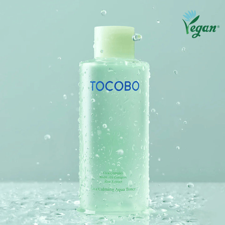 Product image of TOCOBO Cica Calming Aqua Toner surrounded by water droplets that highlight the toner’s moisturizing and soothing properties for sensitive skin.