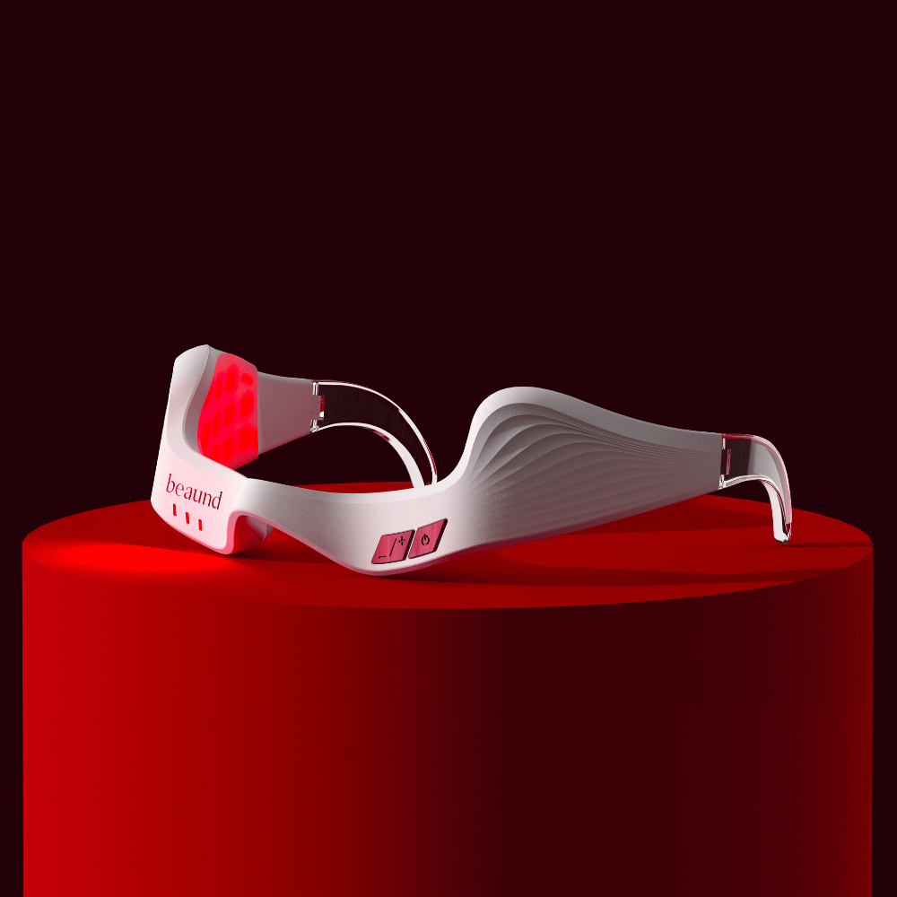 Product image showing Beaund Eye Rejuv with active red LED lighting, placed on a podium for an exclusive and innovative feel.