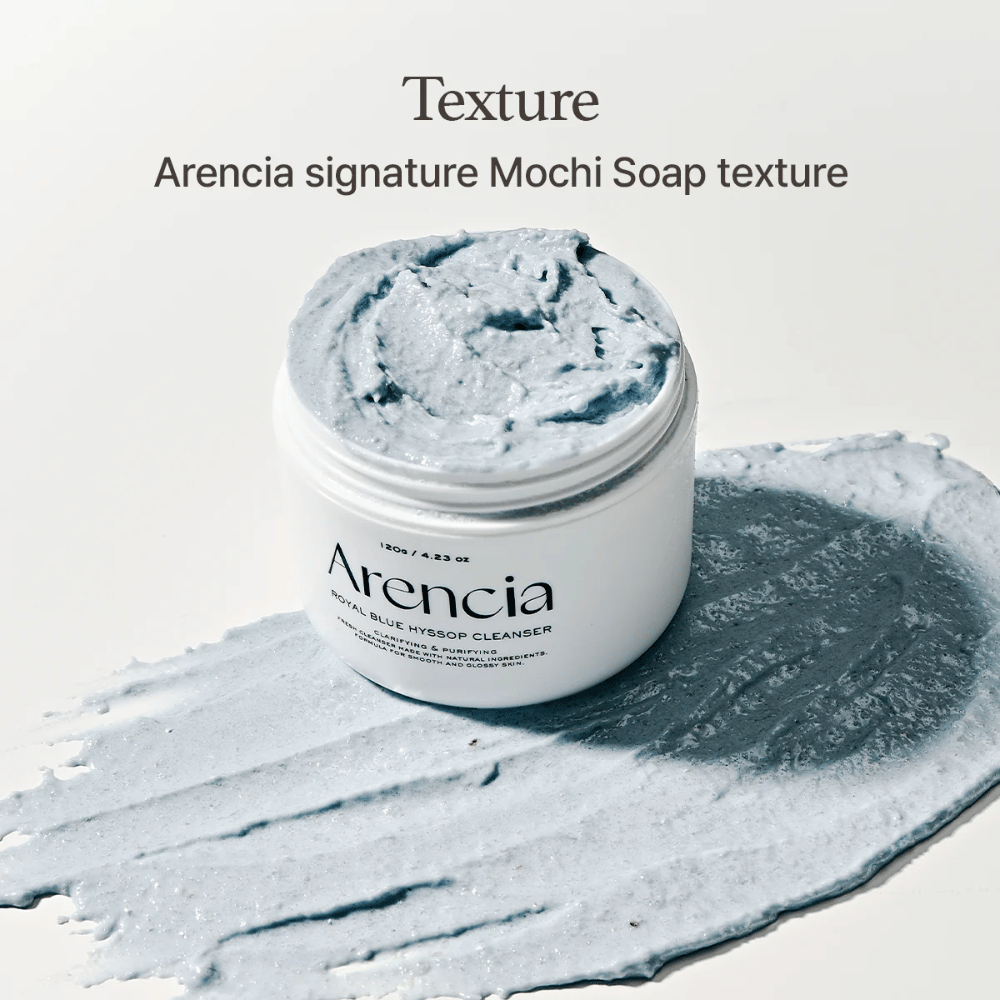 Open jar with Arencia Fresh Blue Hyssop Rice Mochi Cleanser, placed on top of a smeared layer of the blue, creamy cleansing formula showing its mochi-like texture.