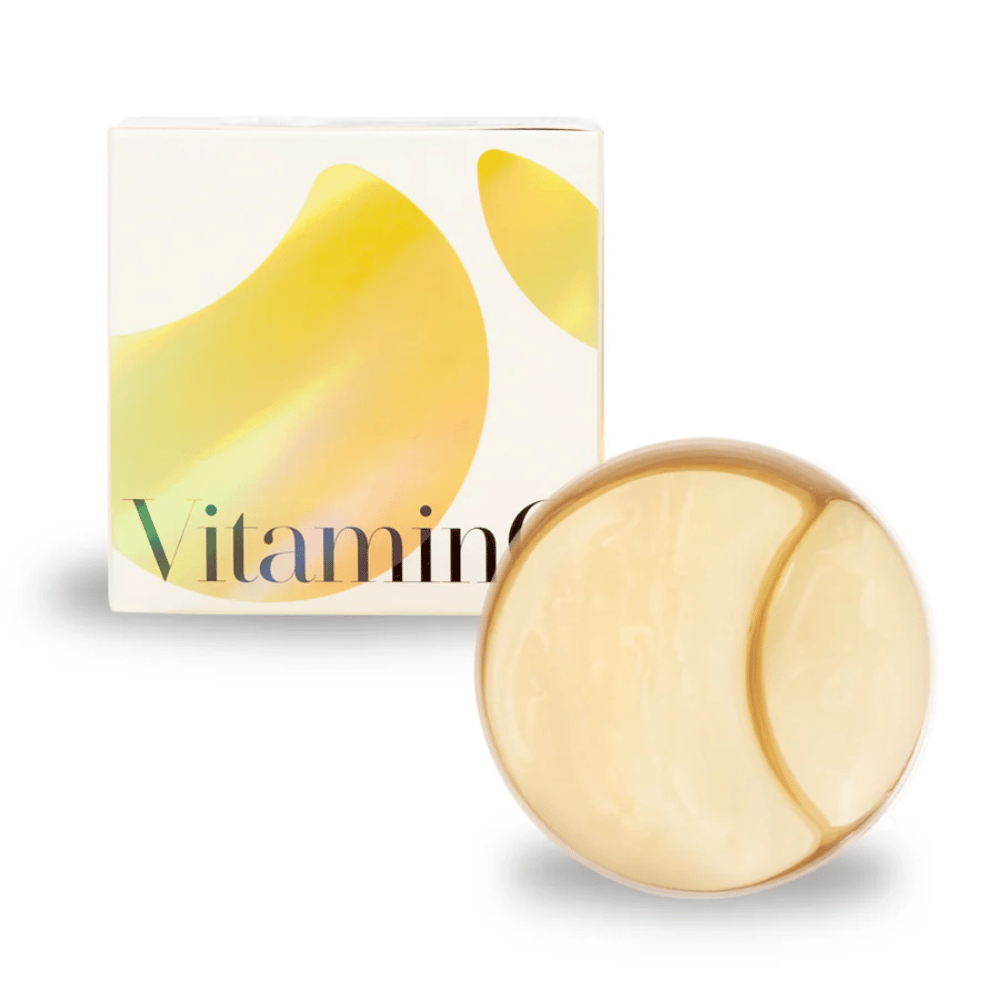 K-Secret Extra Illuminating Eye Gel Patches with vitamin C in gold shimmering hydrogel, jar and packaging in the background.