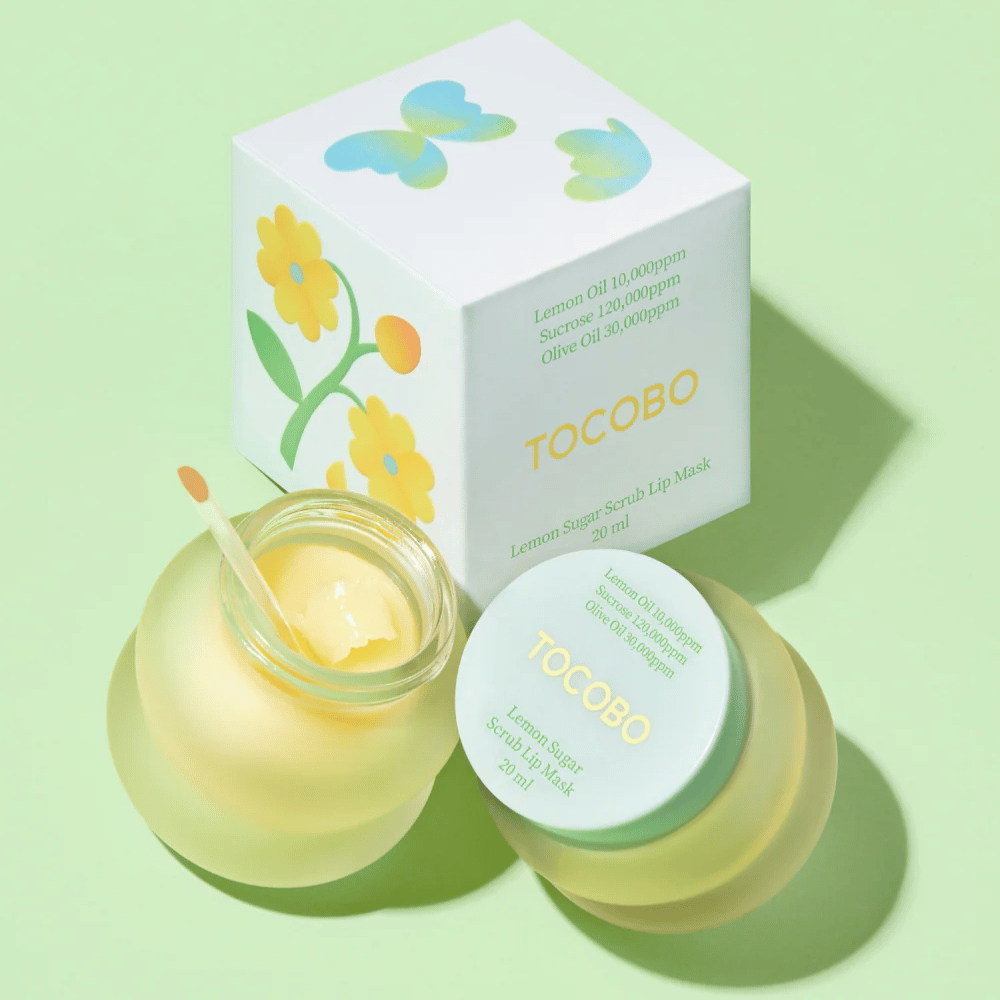 Tocobo Lemon Sugar Scrub Lip Mask together with its packaging with floral design on a light green background.