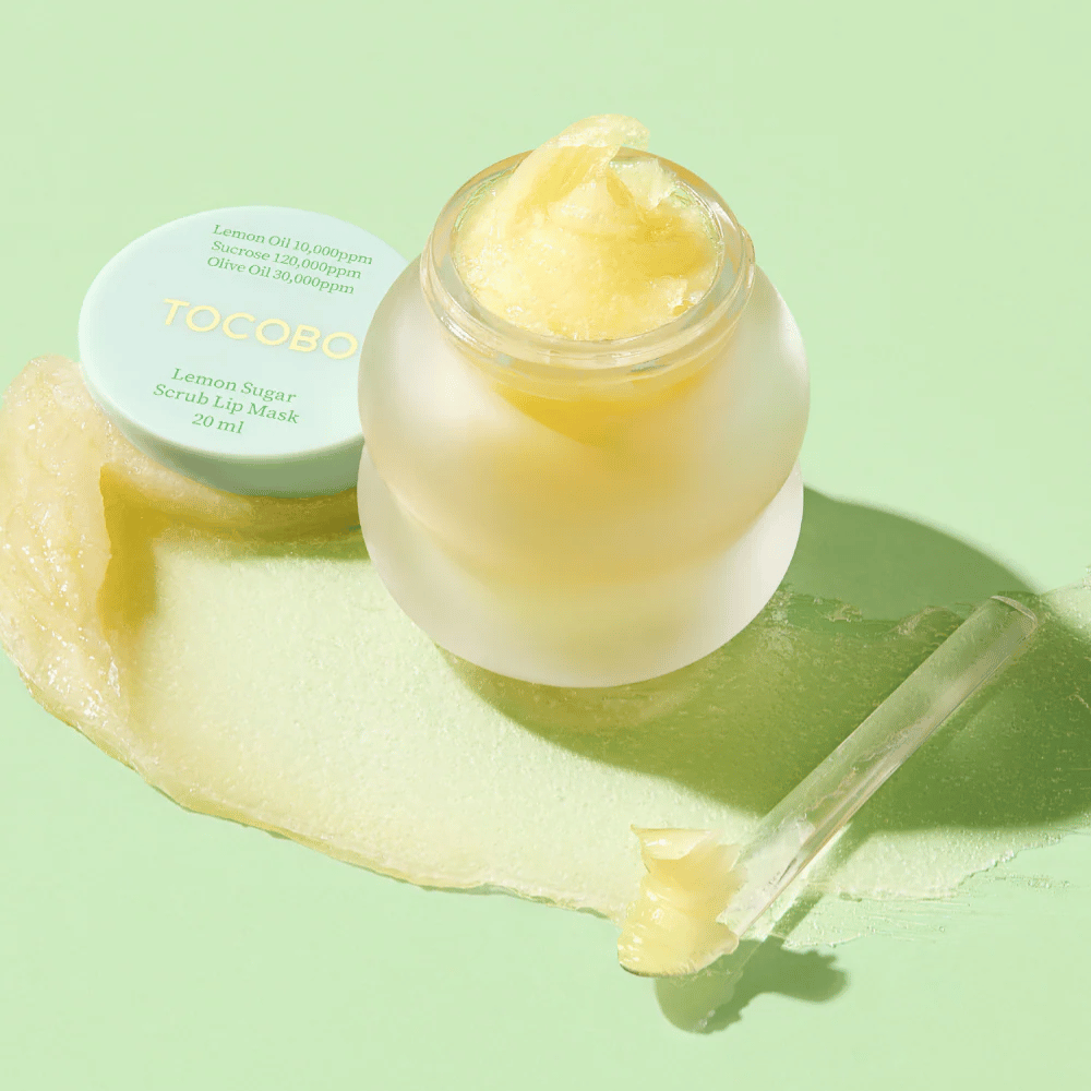 Open jar with Tocobo Lemon Sugar Scrub Lip Mask on a green background, with the contents clearly visible.