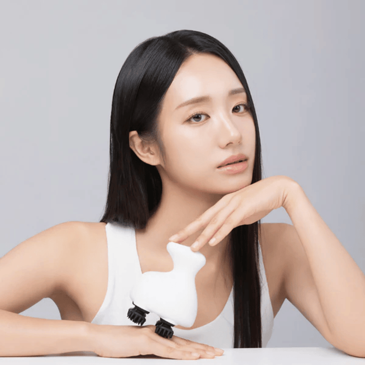 Model poses with Beaund Lift Head Spa and shows the ergonomic design. The image highlights the product as a tool for scalp massage and relaxing self-care.