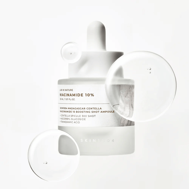SKIN1004 Madagascar Centella Niacinamide 10 Boosting Shot Ampoule with serum drops showcasing a light, fast-absorbing formula with niacinamide, tranexamic acid, and centella.