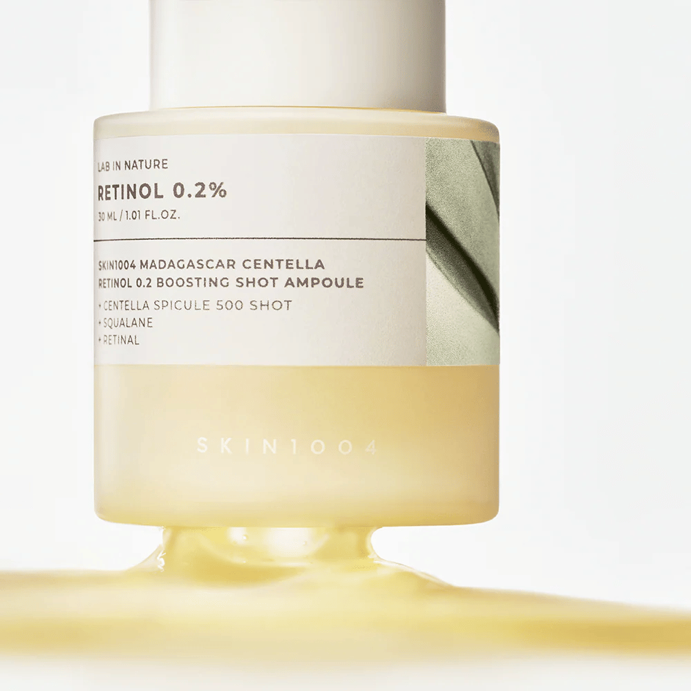 Close-up of SKIN1004 Madagascar Centella Retinol 0.2 Boosting Shot Ampoule showing the light yellow, silky texture of the retinol serum for nightly skin renewal.