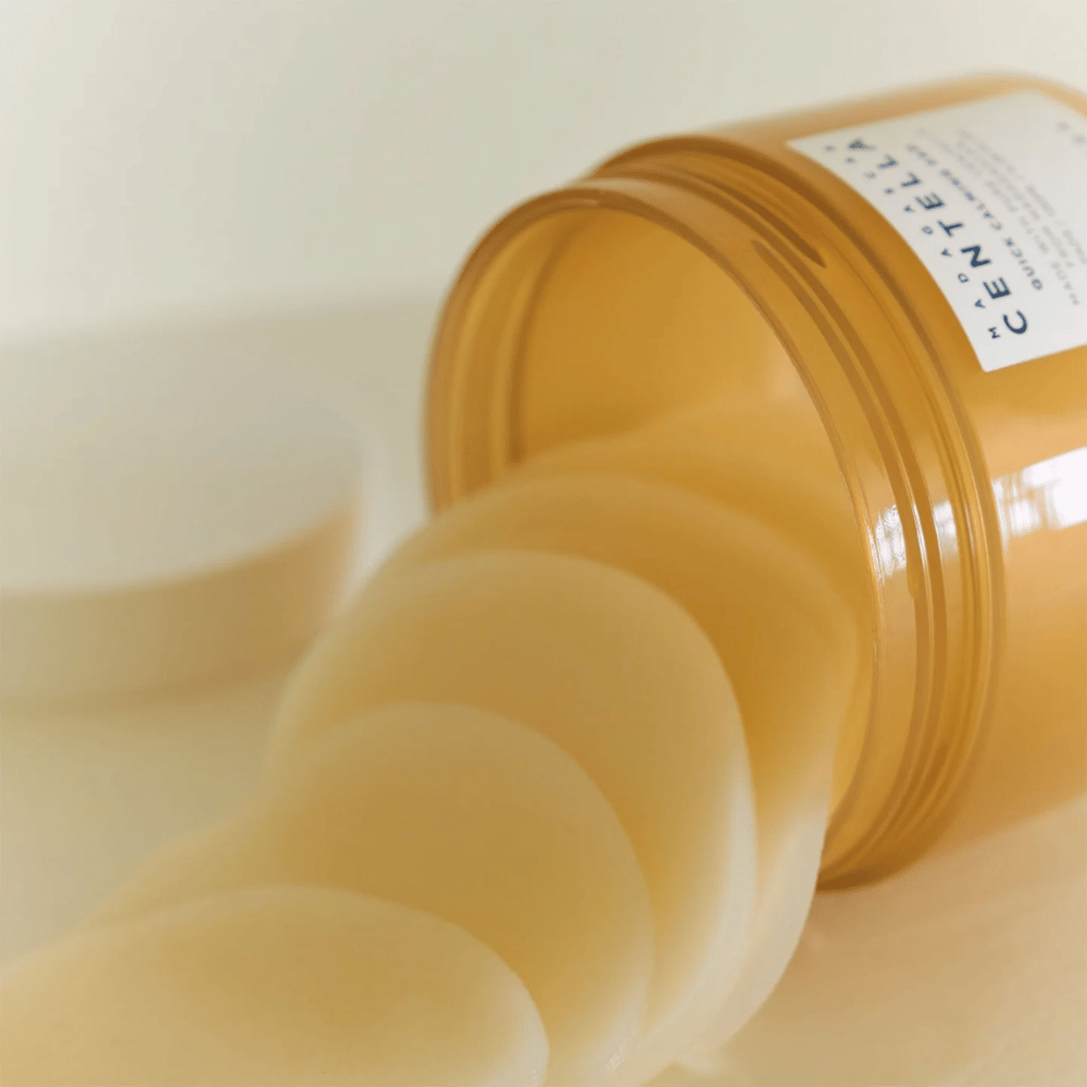 Opened jar with SKIN1004 Madagascar Centella Quick Calming Pad – several round toner pads in light yellow liquid are visible, the jar is amber-colored with a white label.
