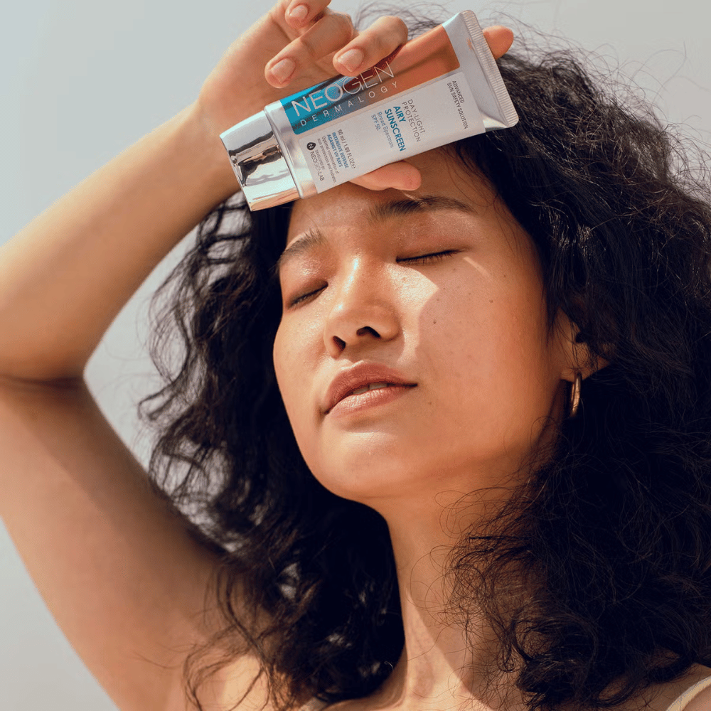 Neogen Dermalogy Day-Light Protection Airy Sunscreen SPF50 50ml – lätt solkräm med bredspektrum UV-skydd, visad i användning i solljus.