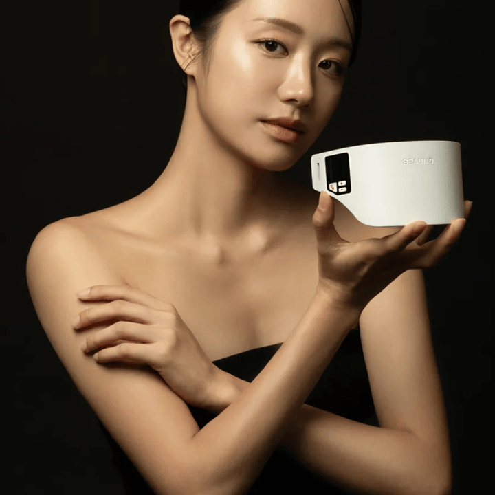 Model holds Beaund Neckcera in hand against a dark background. The image highlights the product's elegant design and premium feel.