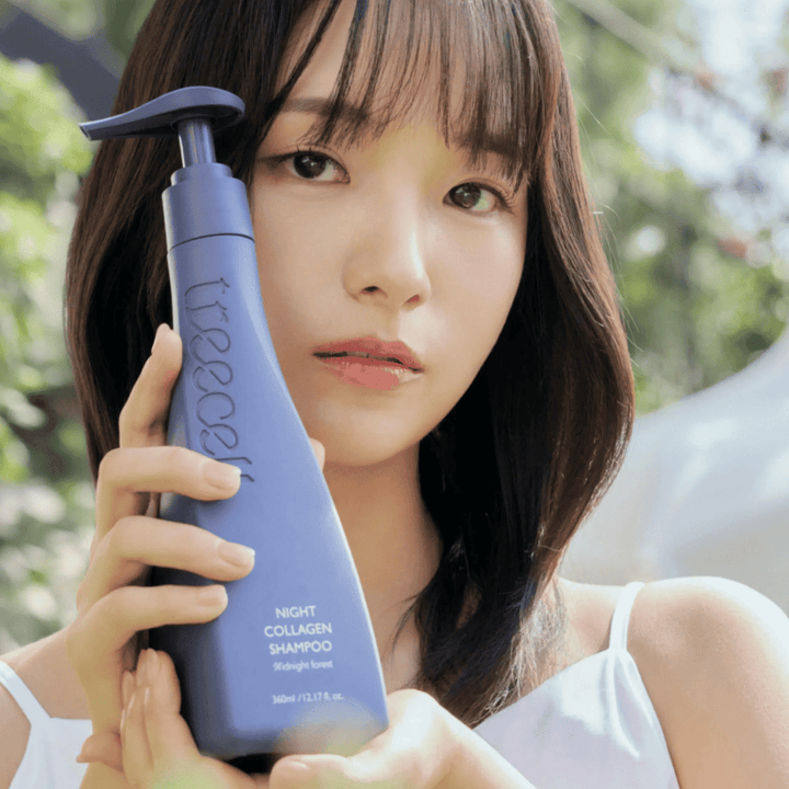 Woman holding up Treecell Night Collagen Shampoo Midnight Forest in a natural setting. The image conveys healthy hair, shine, and a premium feel with a focus on hair and scalp care.