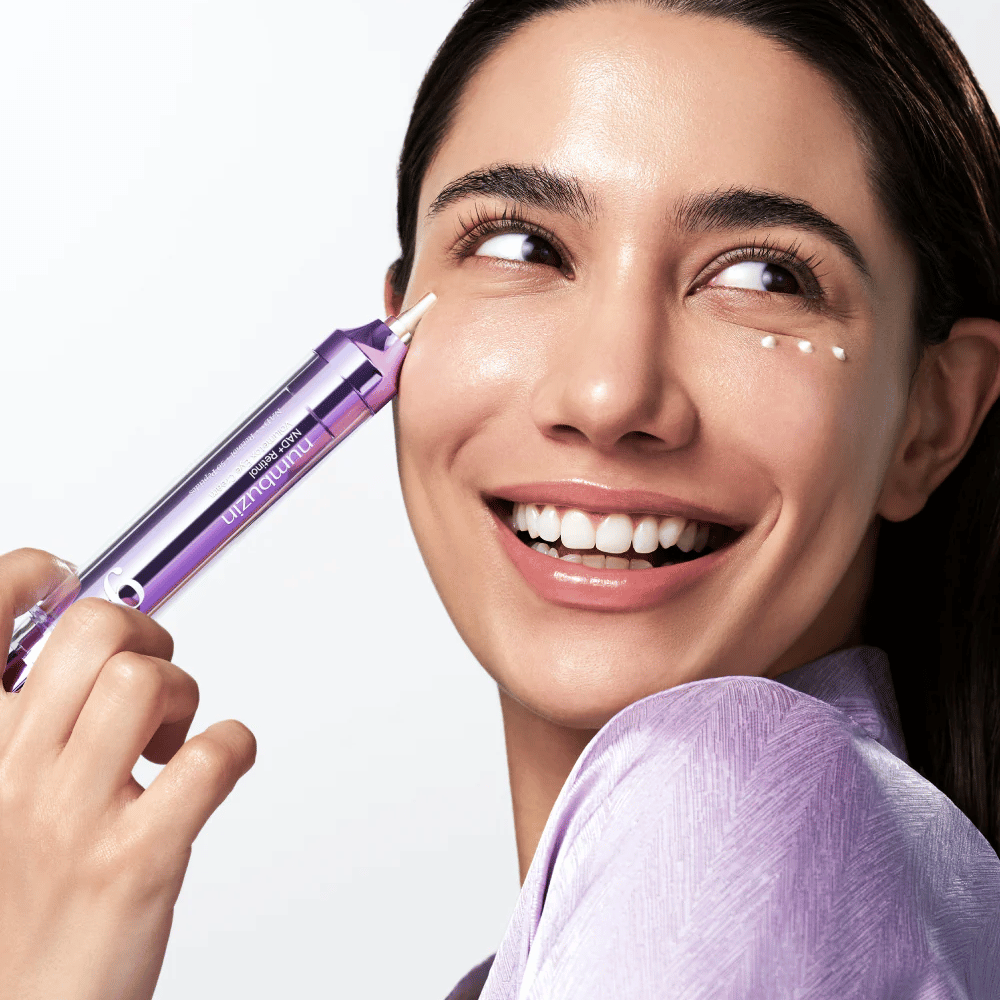 Model applying No.9 NAD+ Retinol Volumetox Eye Cream around the eyes with precision applicator, for targeted care against dark circles and fine lines.
