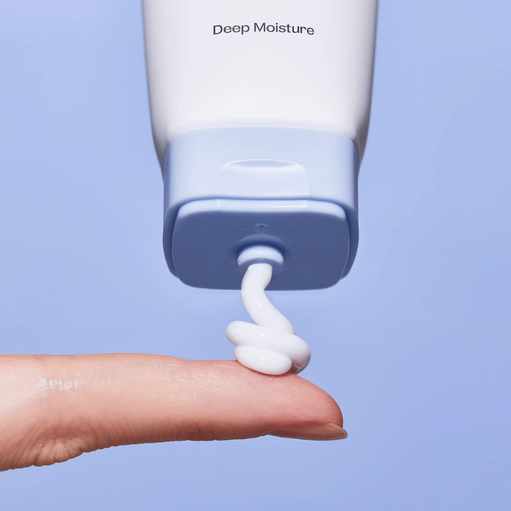 1. Ma:nyo Panthetoin Cream – close-up of white moisturizing face cream being applied from a light blue tube onto a finger