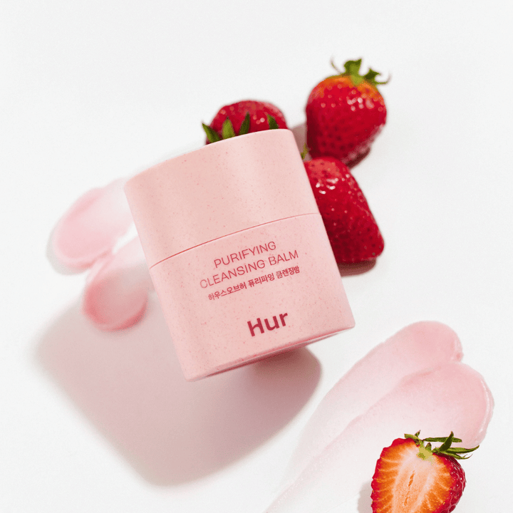 How Purifying Cleansing Balm placed with fresh strawberries. Cleansing balm that gives a smooth skin and is suitable for daily facial cleansing.