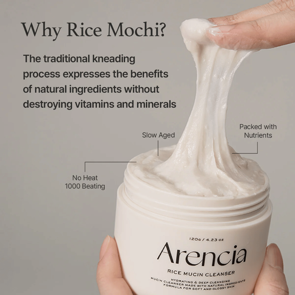 Hand lifting an elastic, white cleansing cream from a jar labeled "Arencia Rice Mucin Cleanser". The text describes traditional kneading that preserves nutrients without destroying vitamins and minerals.