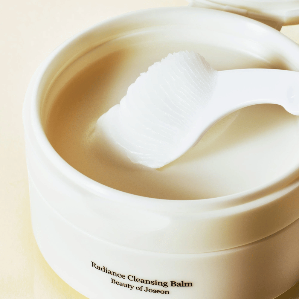 Närbild på Beauty of Joseon Radiance Cleansing Balm i burk med spateln – silkeslen balm som rengör och återfuktar.