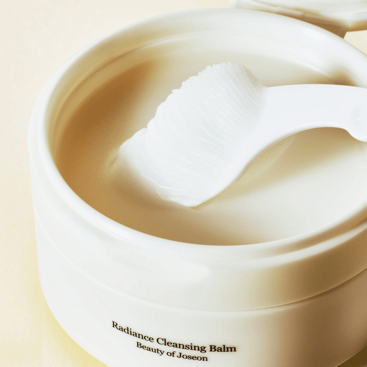 Närbild på Beauty of Joseon Radiance Cleansing Balm i burk med spateln – silkeslen balm som rengör och återfuktar.