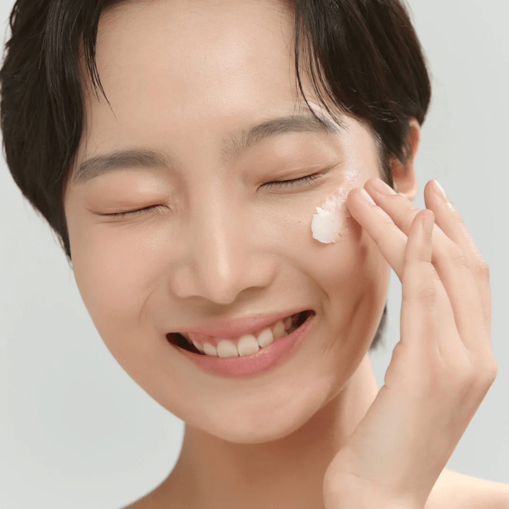 Model with glowing skin applies Beauty of Joseon Radiance Cleansing Balm – Korean cleansing balm that melts away makeup and impurities.