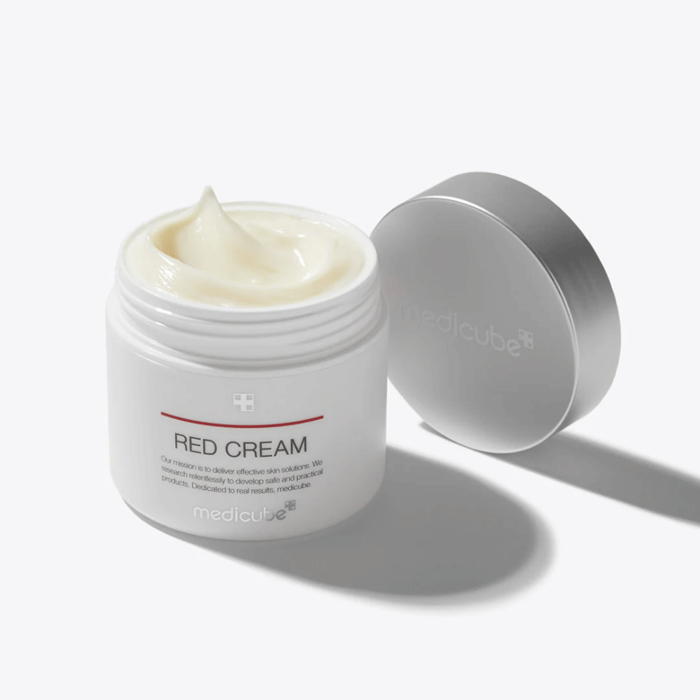 Open jar with medicube Red Cream 50ml – a light yellow face cream in white packaging with a silver lid, developed for acne-prone skin.