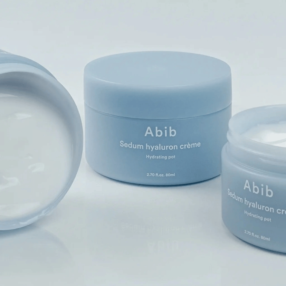 Three jars of Abib Sedum Hyaluron Crème Hydrating Pot 80 ml in light blue minimalist design, one of which is an open jar showing the creamy white consistency.