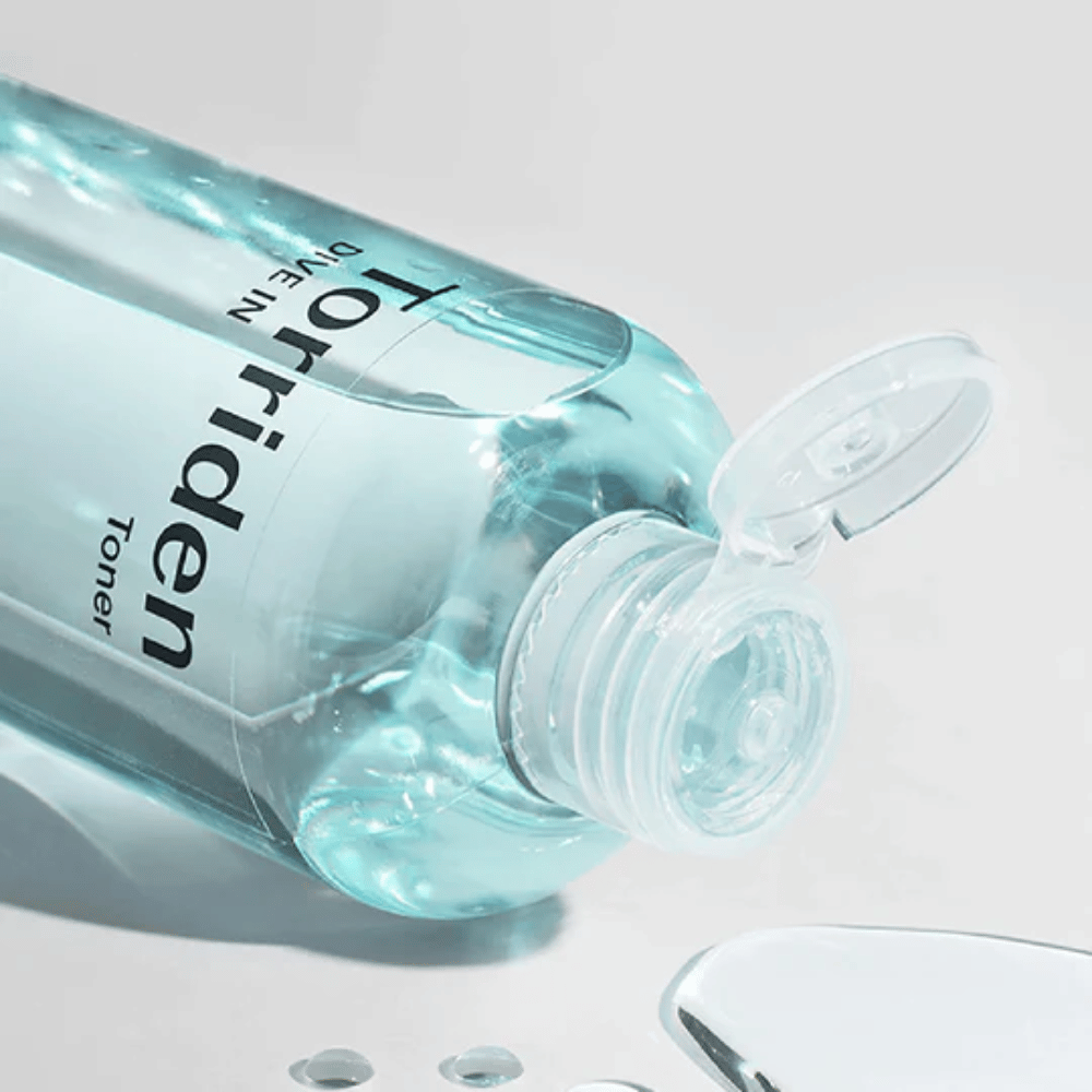 A bottle DIVE-IN Low Molecule Hyaluronic Acid Toner 300ml next to a glass of water, promoting Torriden and hydration.
