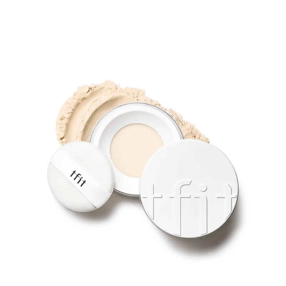 Open compact with TFIT Translucent Set Finishing Powder in the shade Skin Beige, with accompanying puff and setting powder scattered around.