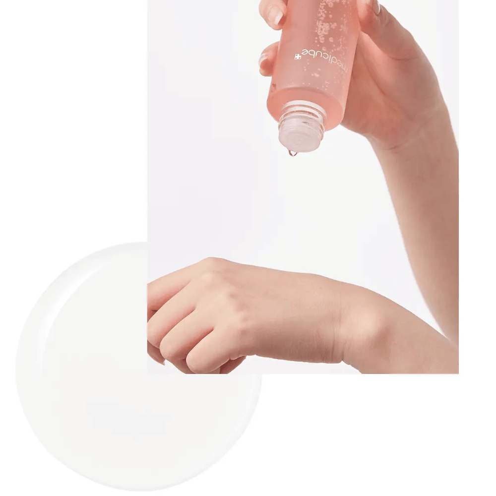 Hand pouring out Medicube Triple Collagen Toner 4.0 from a pink bottle onto the skin, showing the moisturizing consistency.