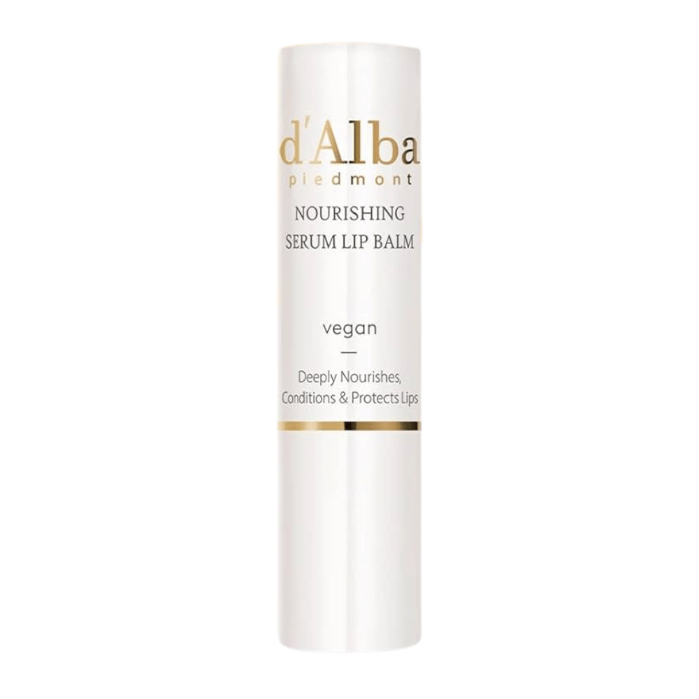 Product image of d'Alba Nourishing Serum Lip Balm in white and gold packaging with the text "vegan" and "Deeply Nourishes, Conditions & Protects Lips".