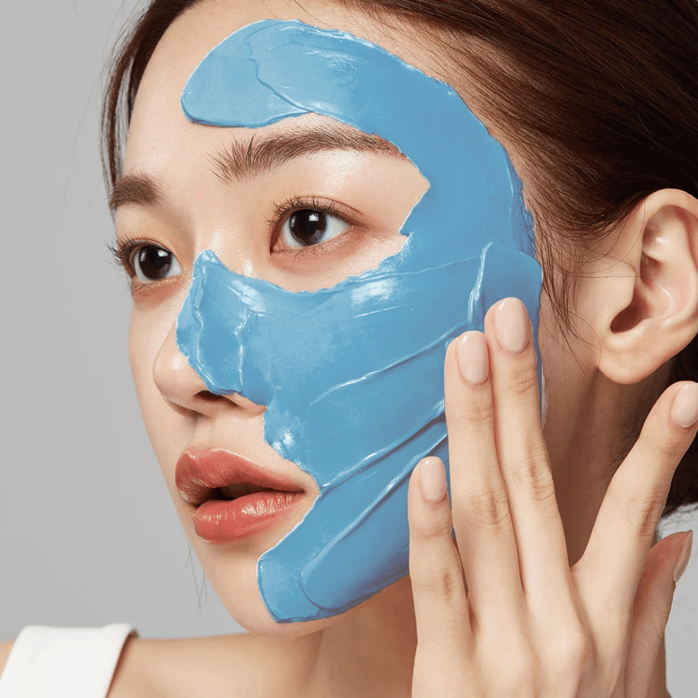 Model with blue face mask from Medicube, covering the T-zone for pore care.