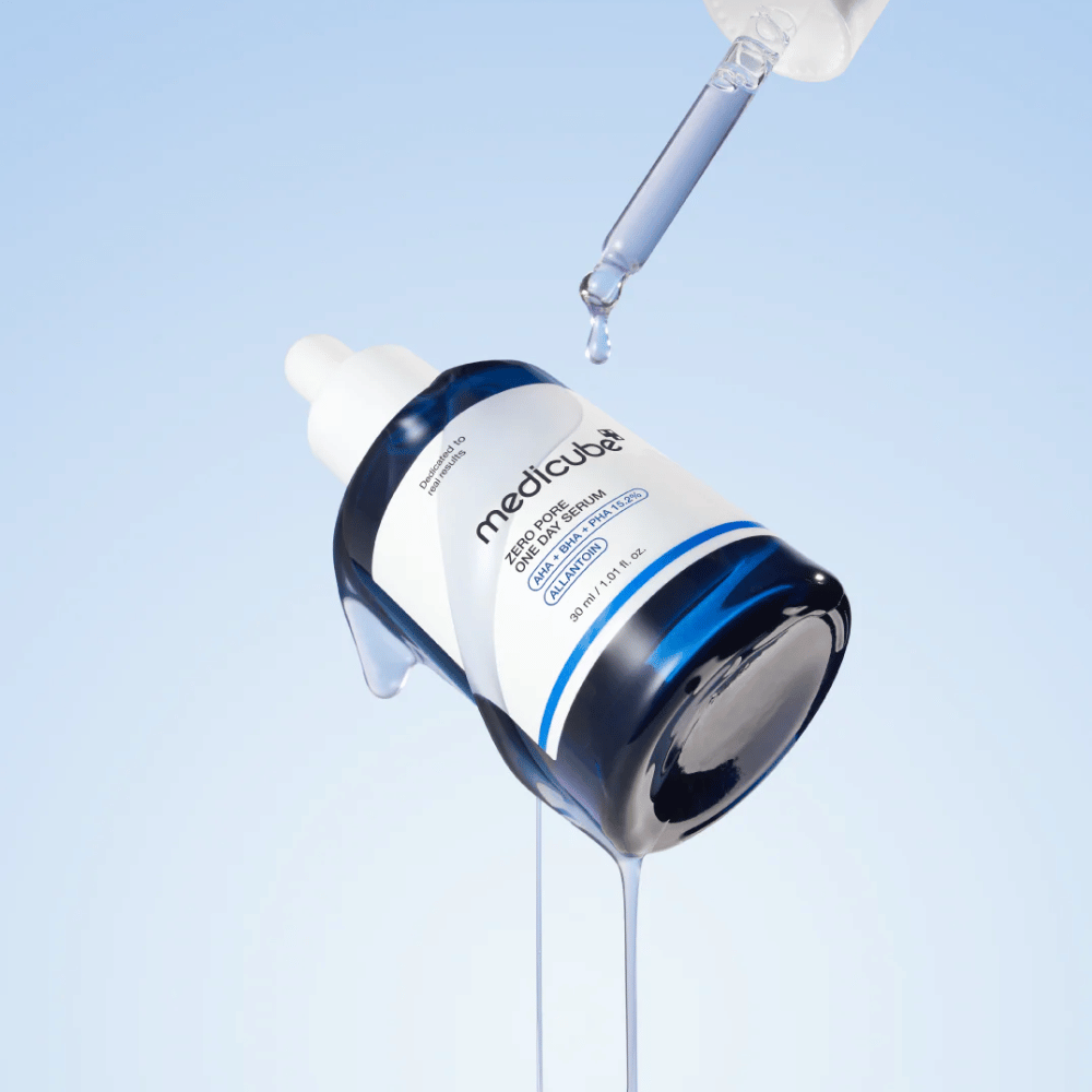 Bottle of Medicube Zero Pore One Day Serum with pipette and running serum drops against a light blue background.