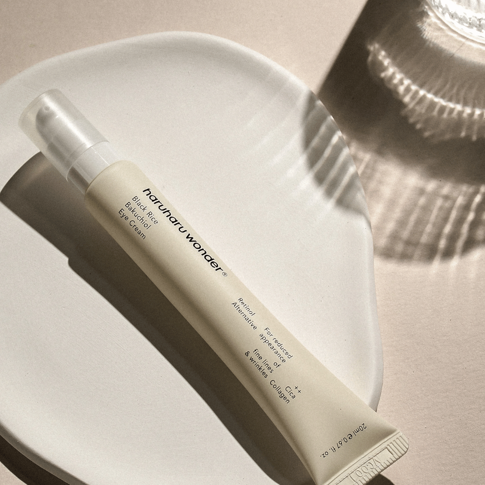 HaruHaru Wonder Black Rice Bakuchiol Eye Cream 20 ml – eye cream with black rice, bakuchiol, and collagen that reduces fine lines and wrinkles, placed on a ceramic plate in soft light.