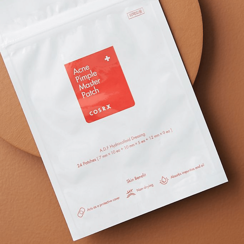 A package COSRX Acne Pimple Master Patch (1pack x 24 patches) on a brown background, with hydrocolloid technology to treat acne and pimples.