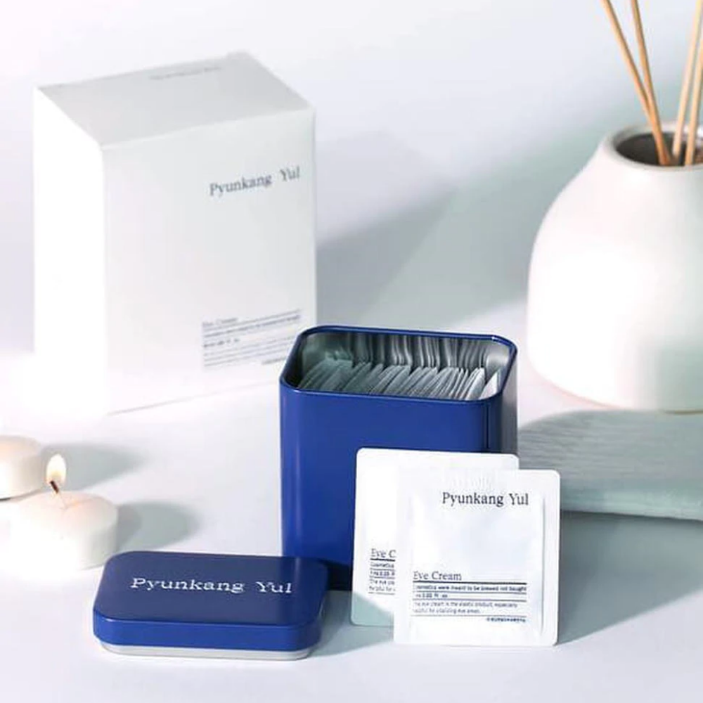 A white box with a blue lid and Pyunkang Yul Eye Cream 1ml x 50pcs next to it.